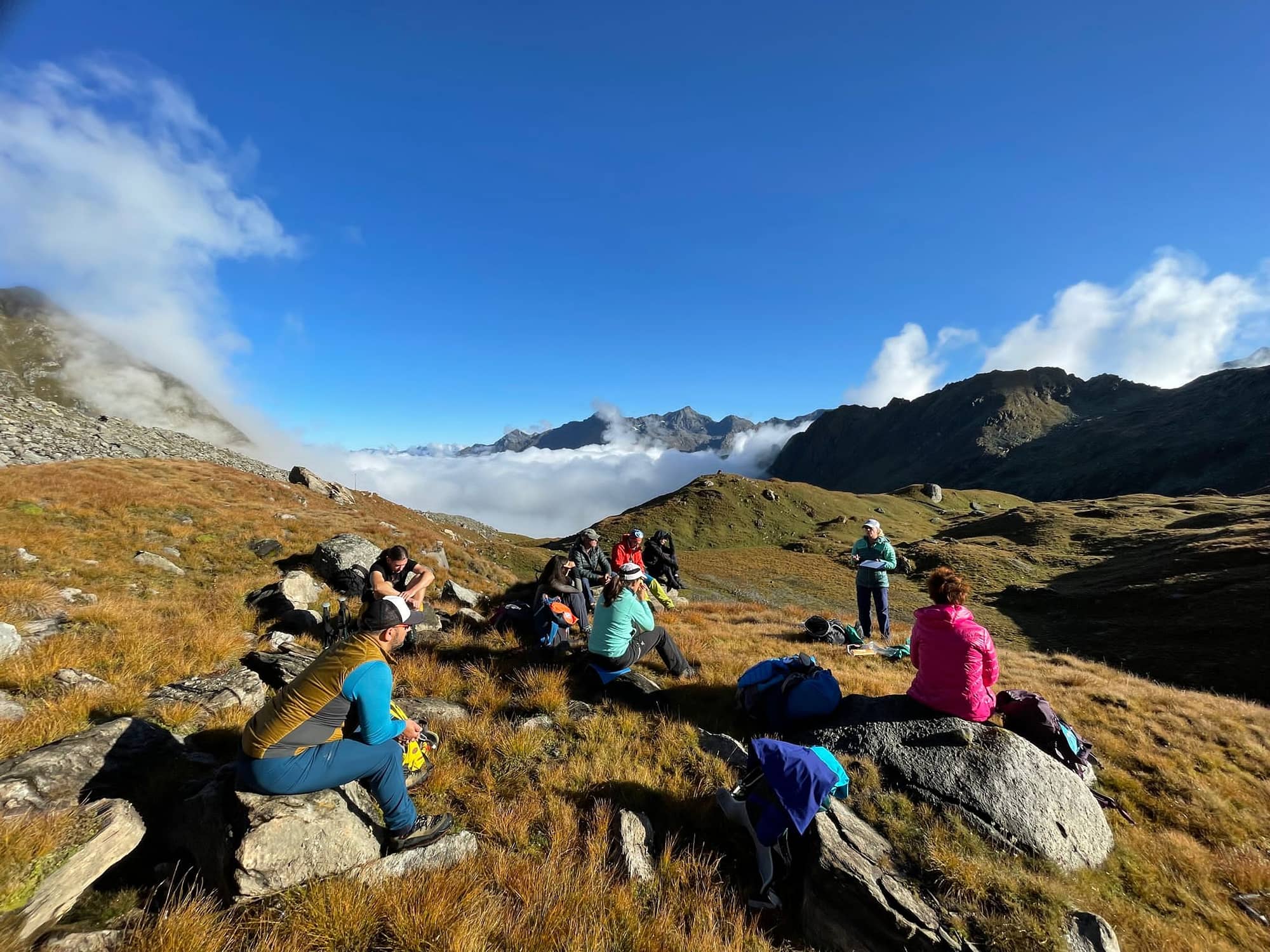 Groupe de personnes assises sur des rochers pendant une randonnée en montagne